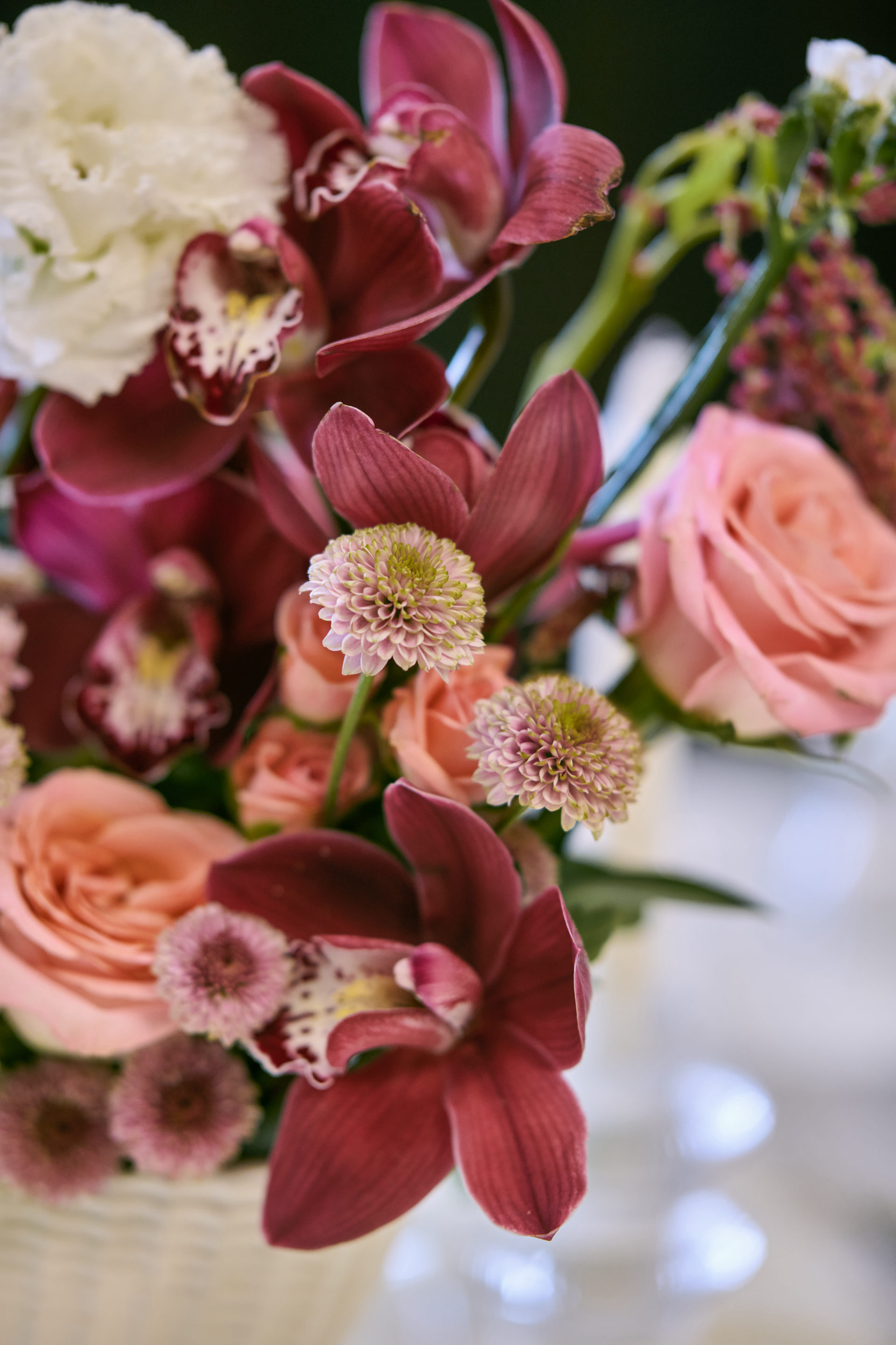 Deep red, pink and white wedding table centerpiece with taper candles at a Dubai reception, by Flower Corner — photo 12