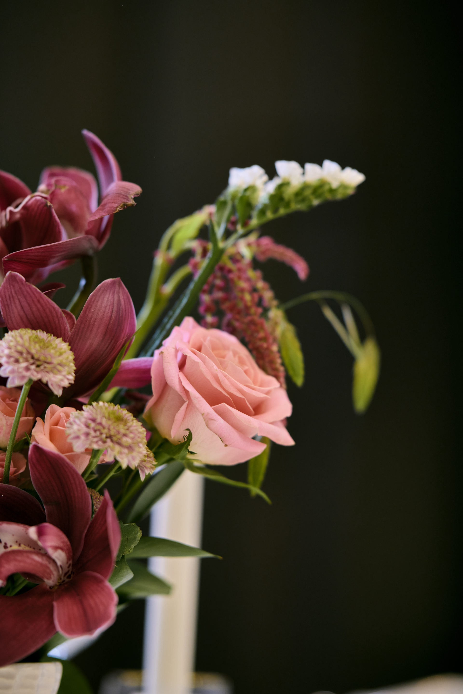Deep red, pink and white wedding table centerpiece with taper candles at a Dubai reception, by Flower Corner — photo 14