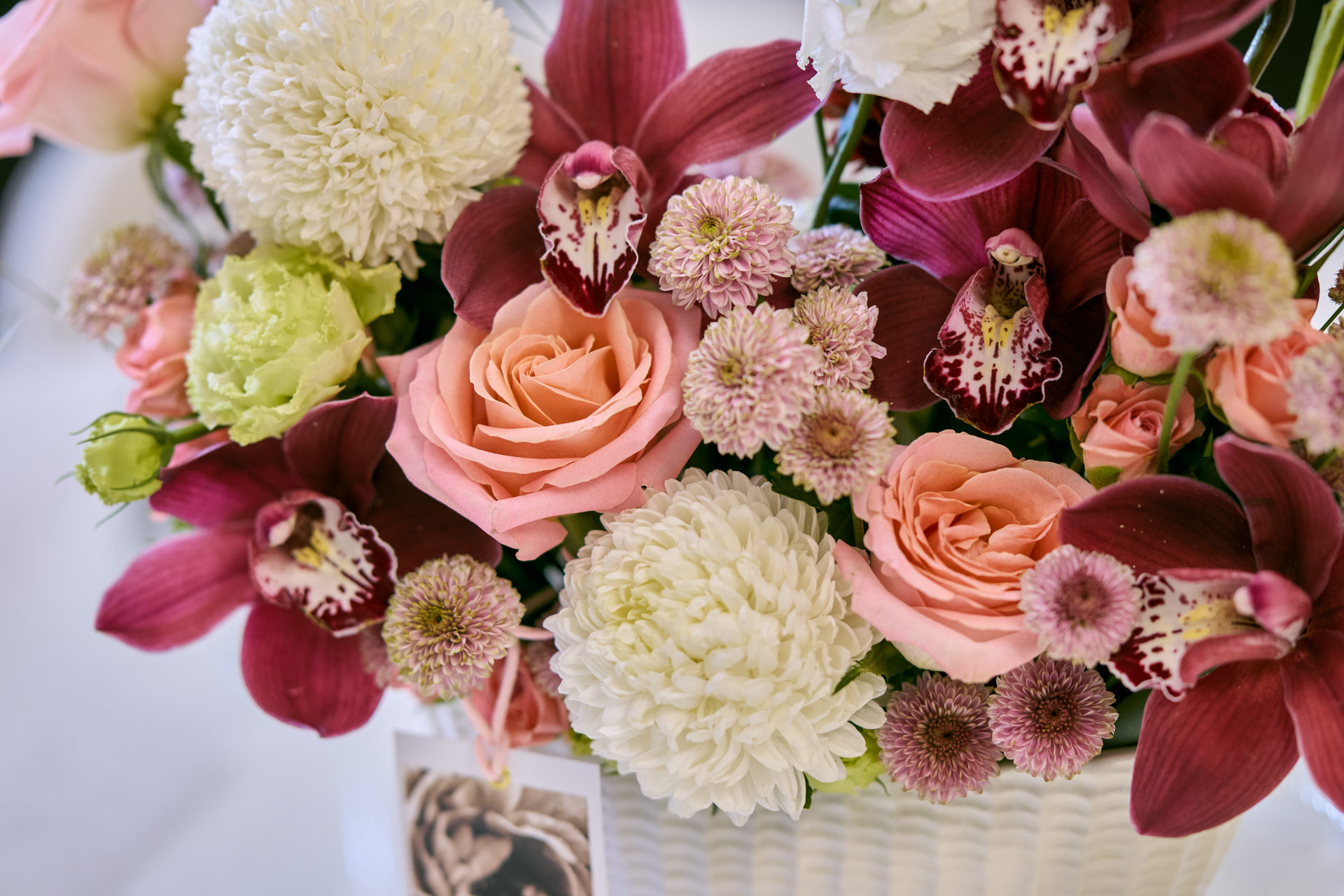 Deep red, pink and white wedding table centerpiece with taper candles at a Dubai reception, by Flower Corner — photo 18