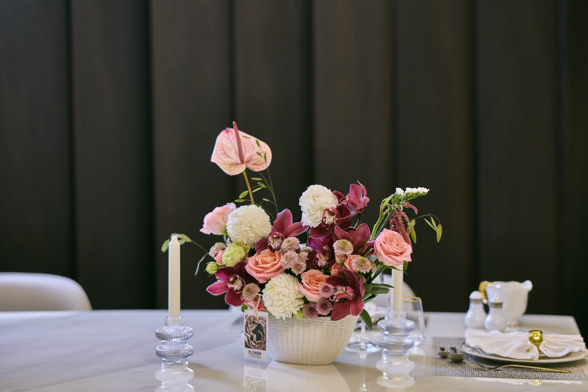 Deep red, pink and white wedding table centerpiece with taper candles at a Dubai reception, by Flower Corner — photo 21