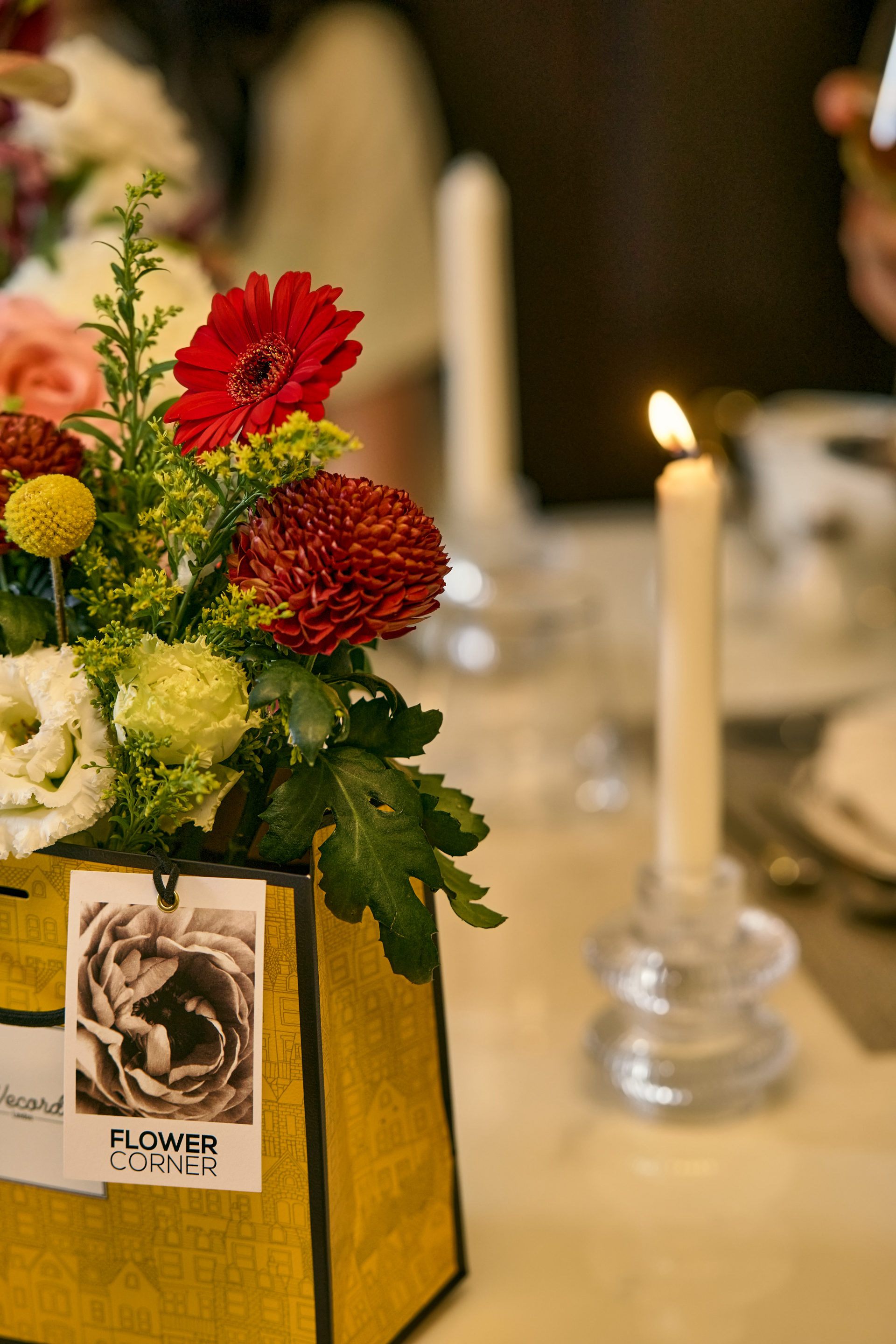 Deep red, pink and white wedding table centerpiece with taper candles at a Dubai reception, by Flower Corner — photo 43