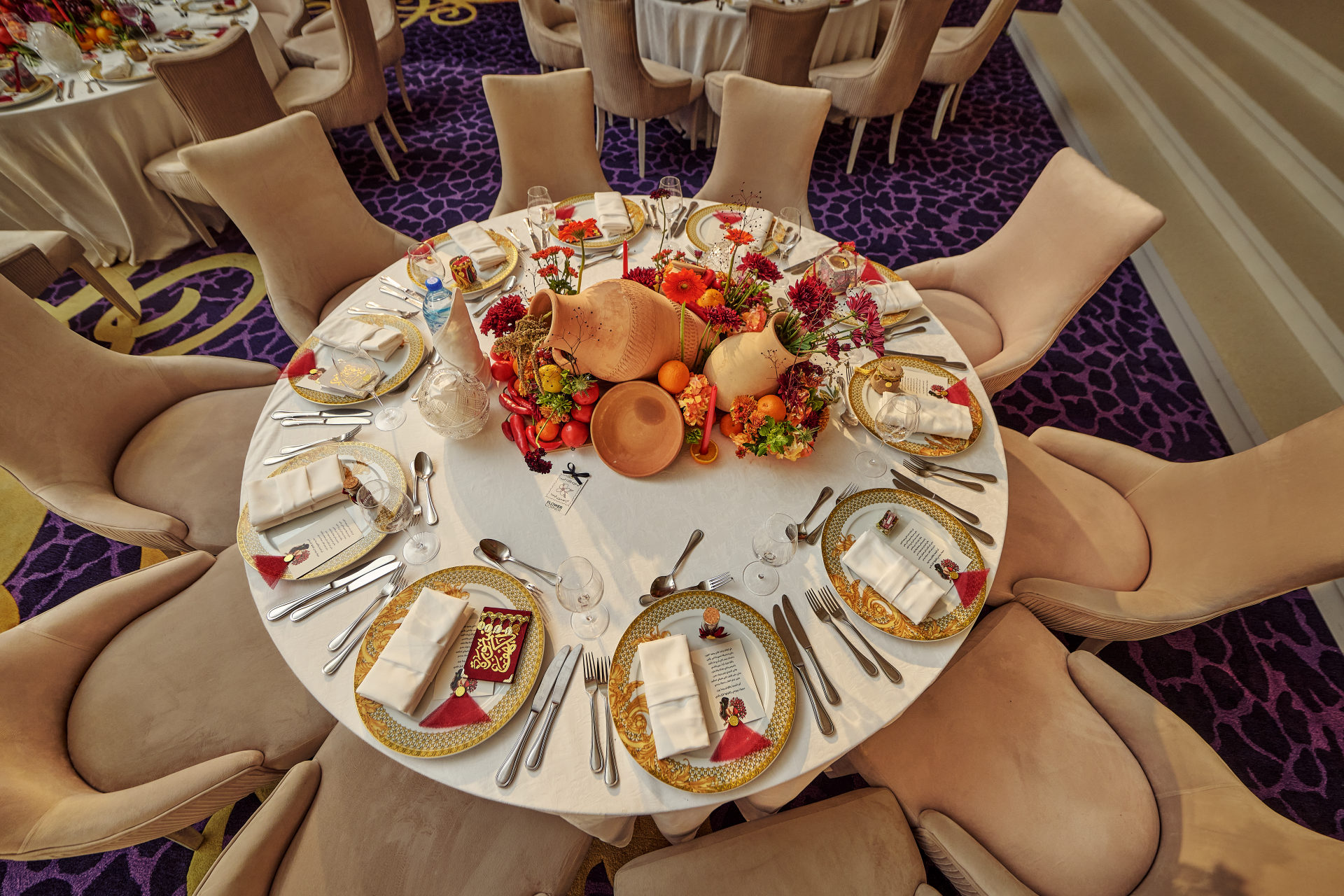 Deep red, pink and white wedding table centerpiece with taper candles at a Dubai reception, by Flower Corner — photo 178