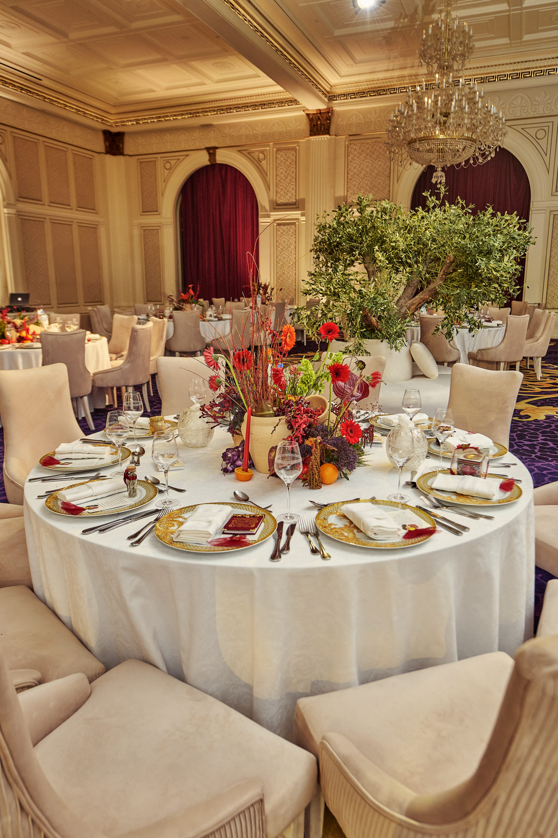 Deep red, pink and white wedding table centerpiece with taper candles at a Dubai reception, by Flower Corner — photo 182