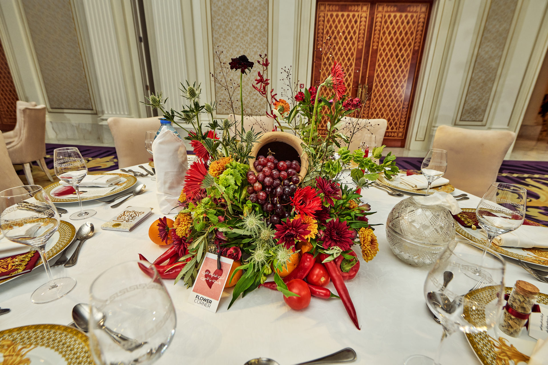 Deep red, pink and white wedding table centerpiece with taper candles at a Dubai reception, by Flower Corner — photo 186