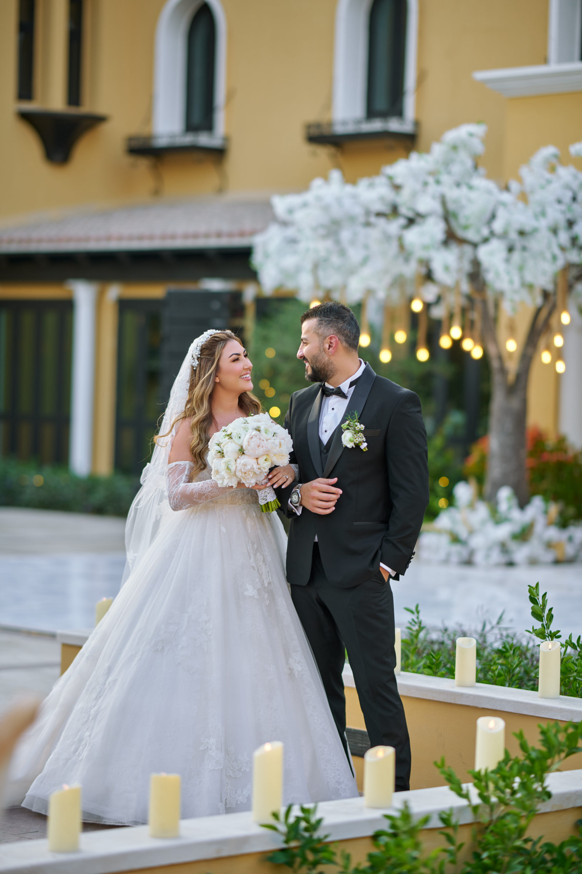 Bride and groom at a white floral arch and ceremony backdrop in Dubai, flowers by Flower Corner — photo 1228