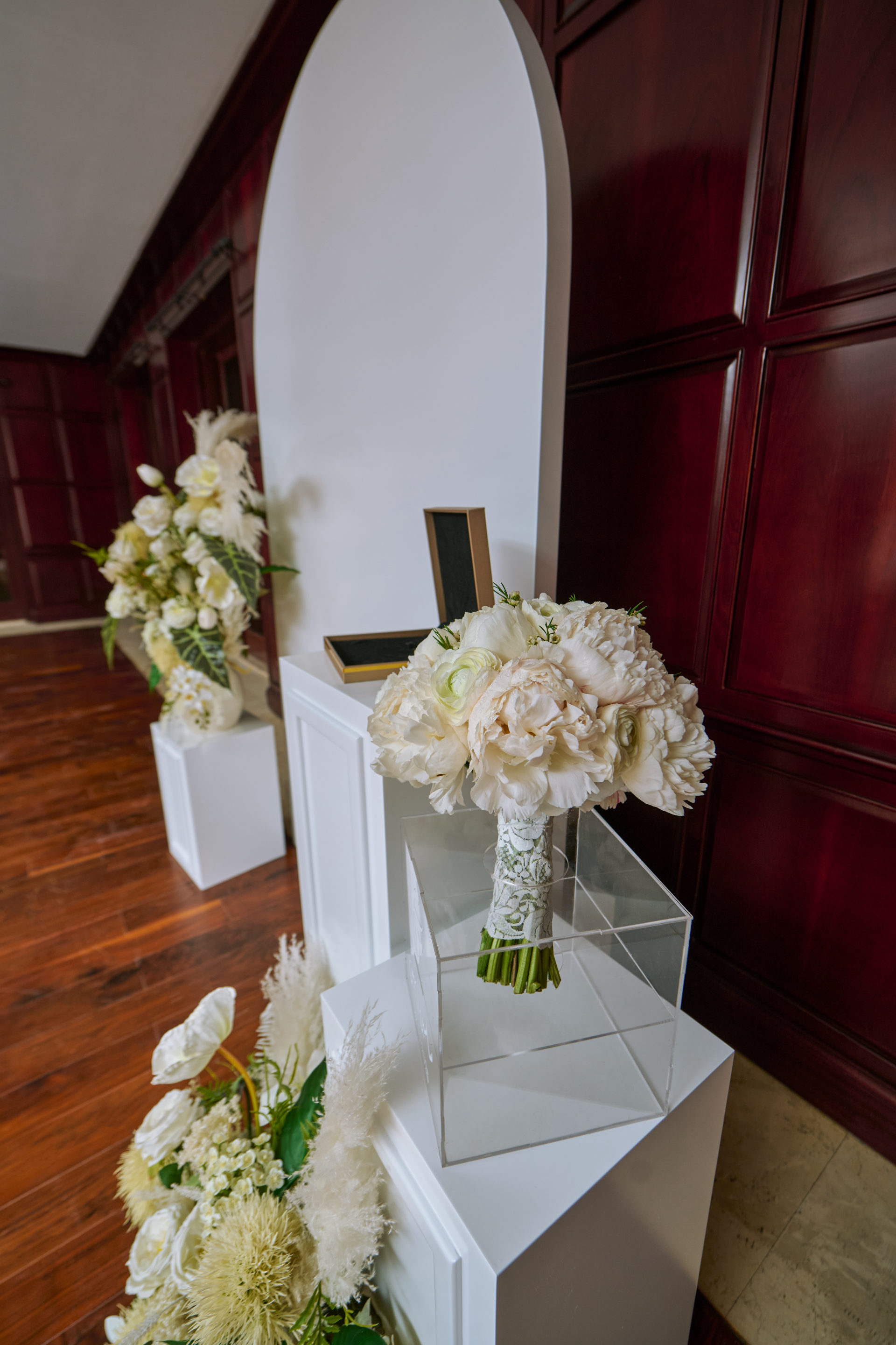 Bride and groom at a white floral arch and ceremony backdrop in Dubai, flowers by Flower Corner — photo 1231